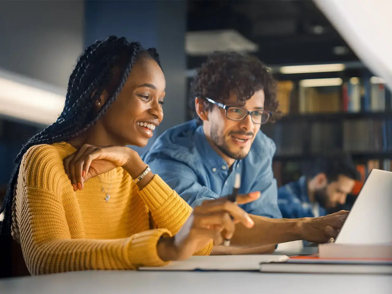 Smiling woman and man working at computer.