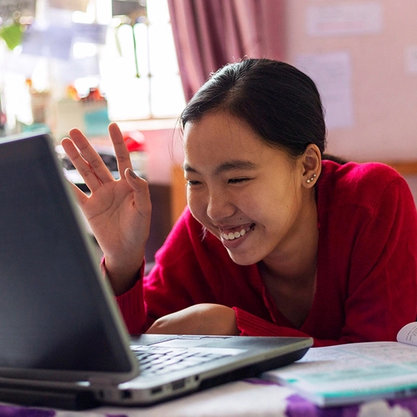Young girl uses her laptop for virtual class from her home