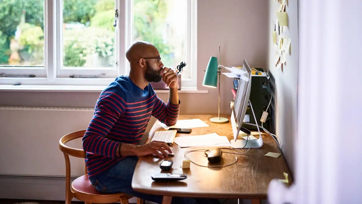 A man works on an apple iMac computer