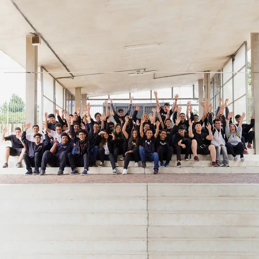 A large group of students wave their hands in the air